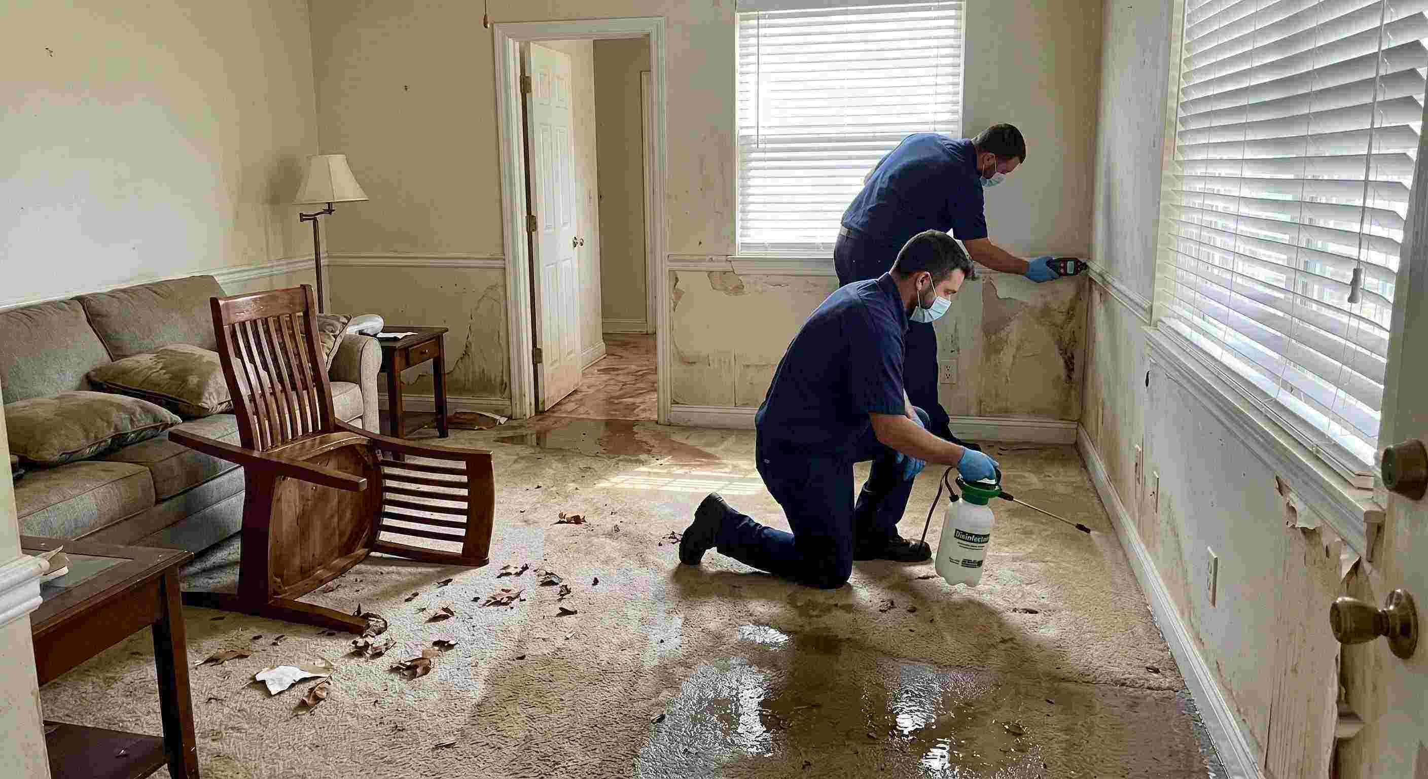 Technicians performing flood disinfection after water damage inside a home in St. Petersburg, ensuring wet floors, damp walls, and household items are sanitized safely.