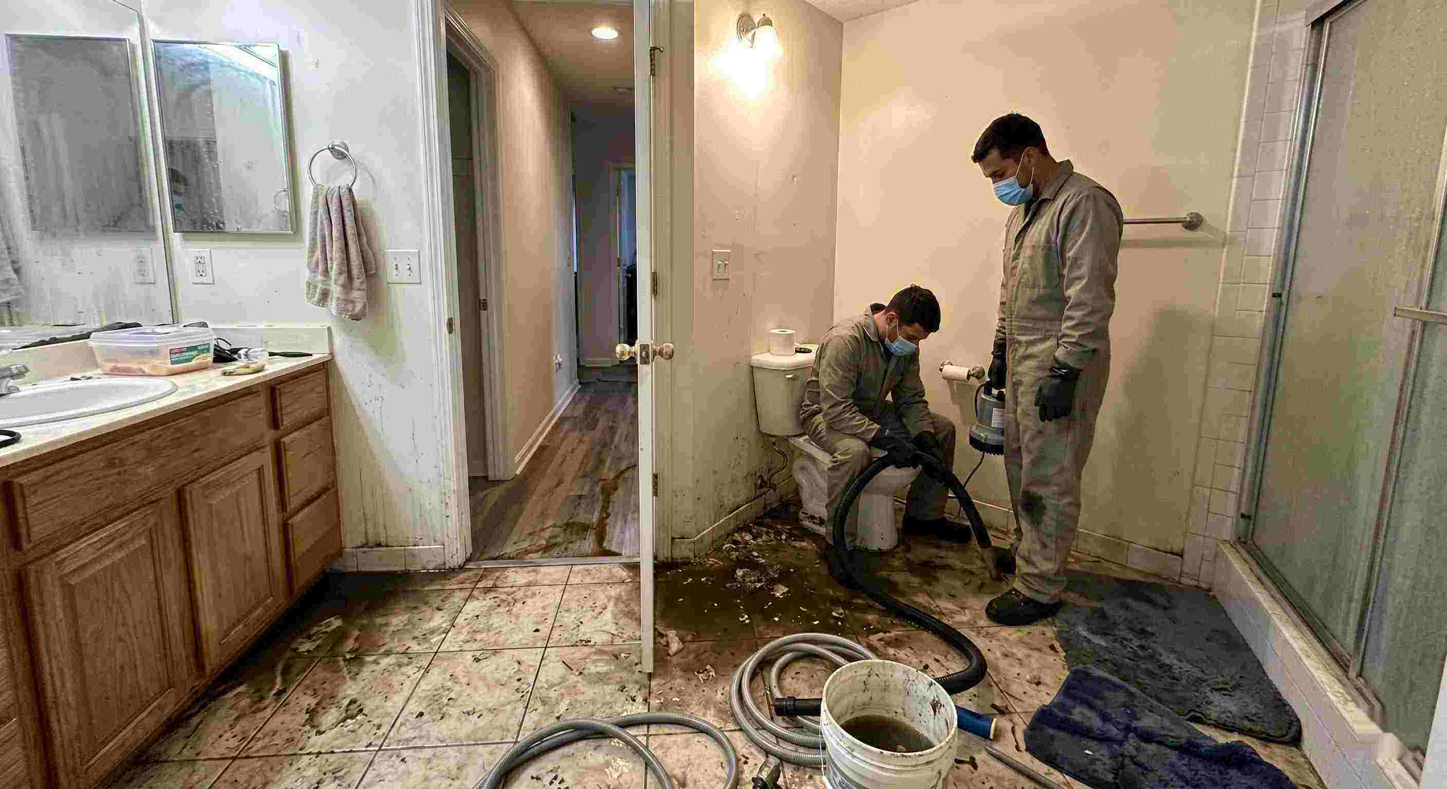 Septic tank backup cleanup in St. Petersburg bathroom with technicians removing contaminated water and sanitizing affected areas